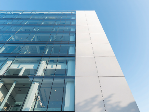 Modern office building exterior with glass facade under a clear blue sky, symbolizing the organization's headquarters.